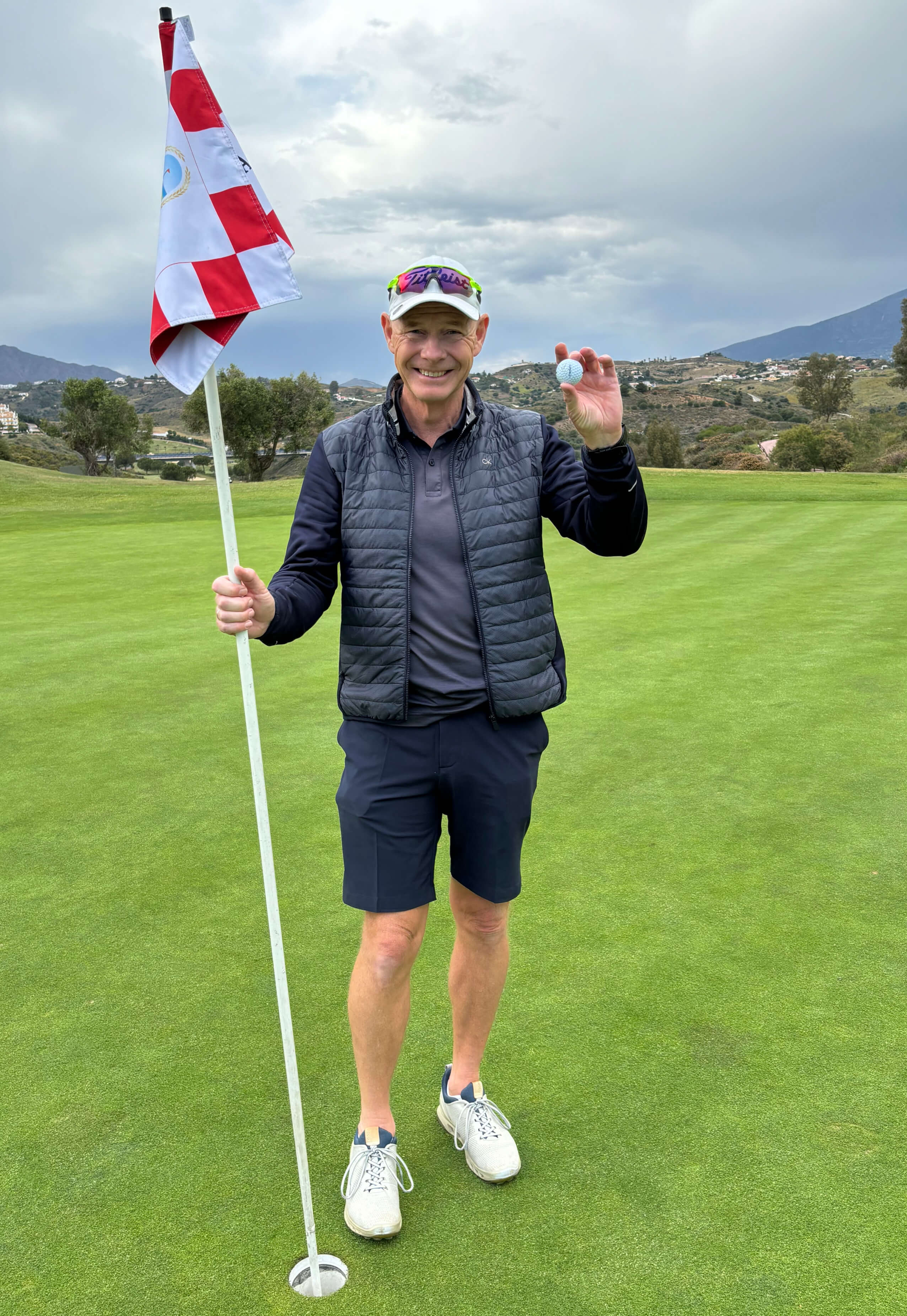 Profilbilde av Rolf fra Apex Golf, som smiler på greenen etter en hole-in-one med hullflagg i den ene hånden og ball i andre.